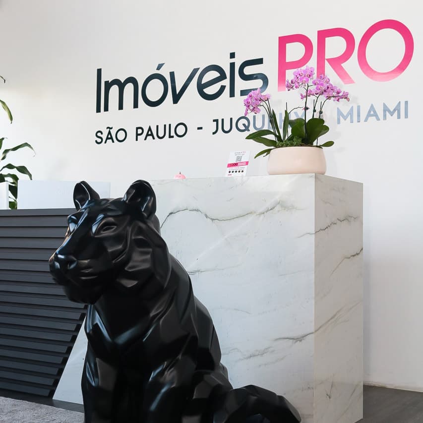 A escultura de pantera e a marca Imóveis PRO na recepção