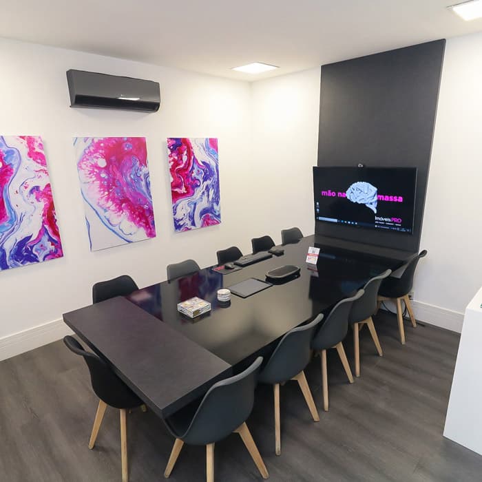 Sala de reunião com mesa e iluminação escultural