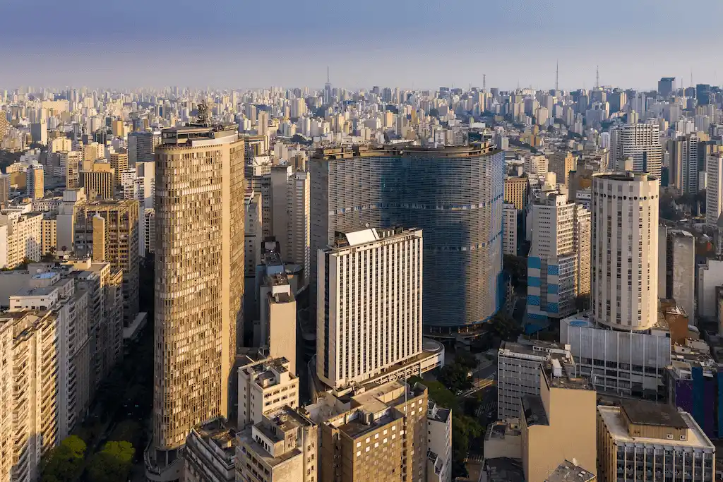 Vista aérea do centro de São Paulo com edifícios icônicos e arquitetura modernista, como o Copan e o edifício Itália.