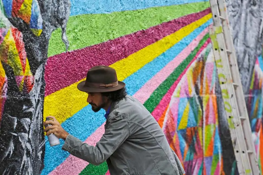 homem fazendo grafite na parede