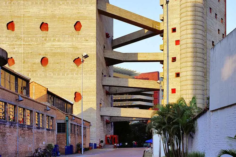 uma rua com dois edifícios e galpões ao lado