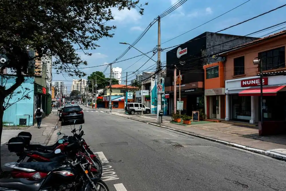rua em brooklin sp, com comércios, motos e carros